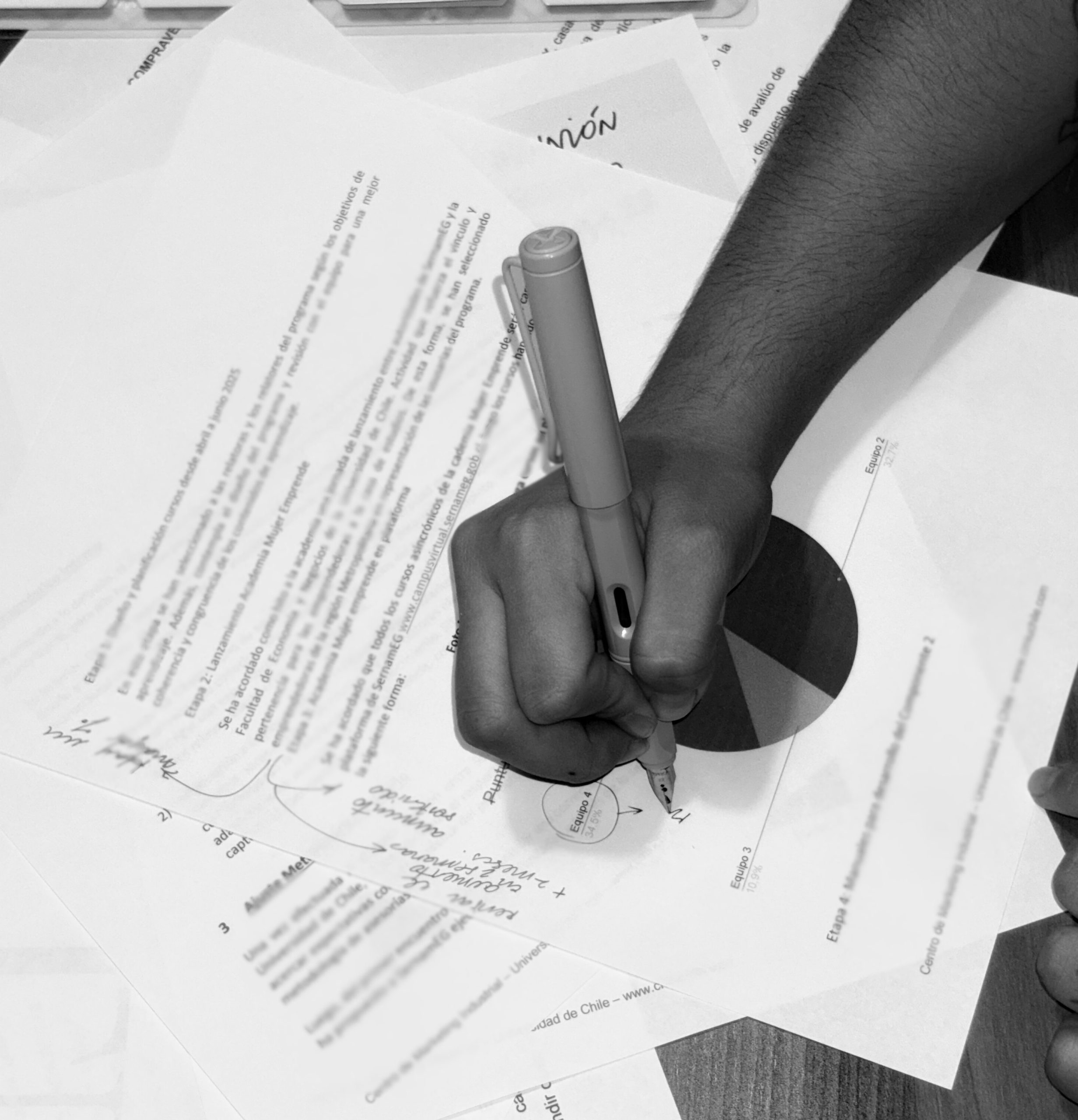 Persona haciendo anotaciones en un documento con una pluma.